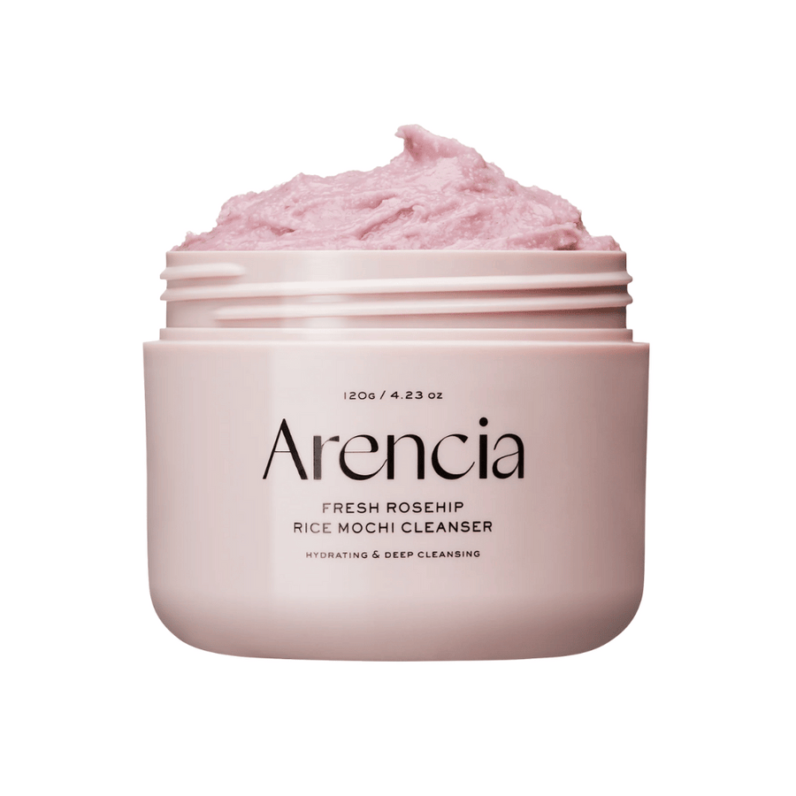 Närbild på en rosa burk med Arencia Royal Rosehip Cleanser, fylld med rosa rengöringskräm med vispad, mochi-liknande textur. Text på burken visar att produkten återfuktar och rengör på djupet.