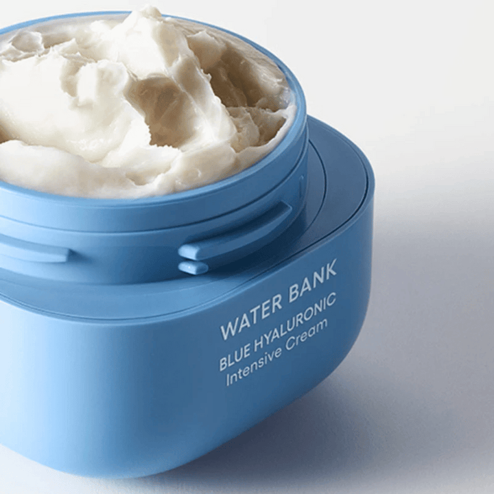 Öppen burk av LANEIGE Water Bank Blue Hyaluronic Intensive Cream som visar den rika krämiga konsistensen, mot ljus bakgrund.