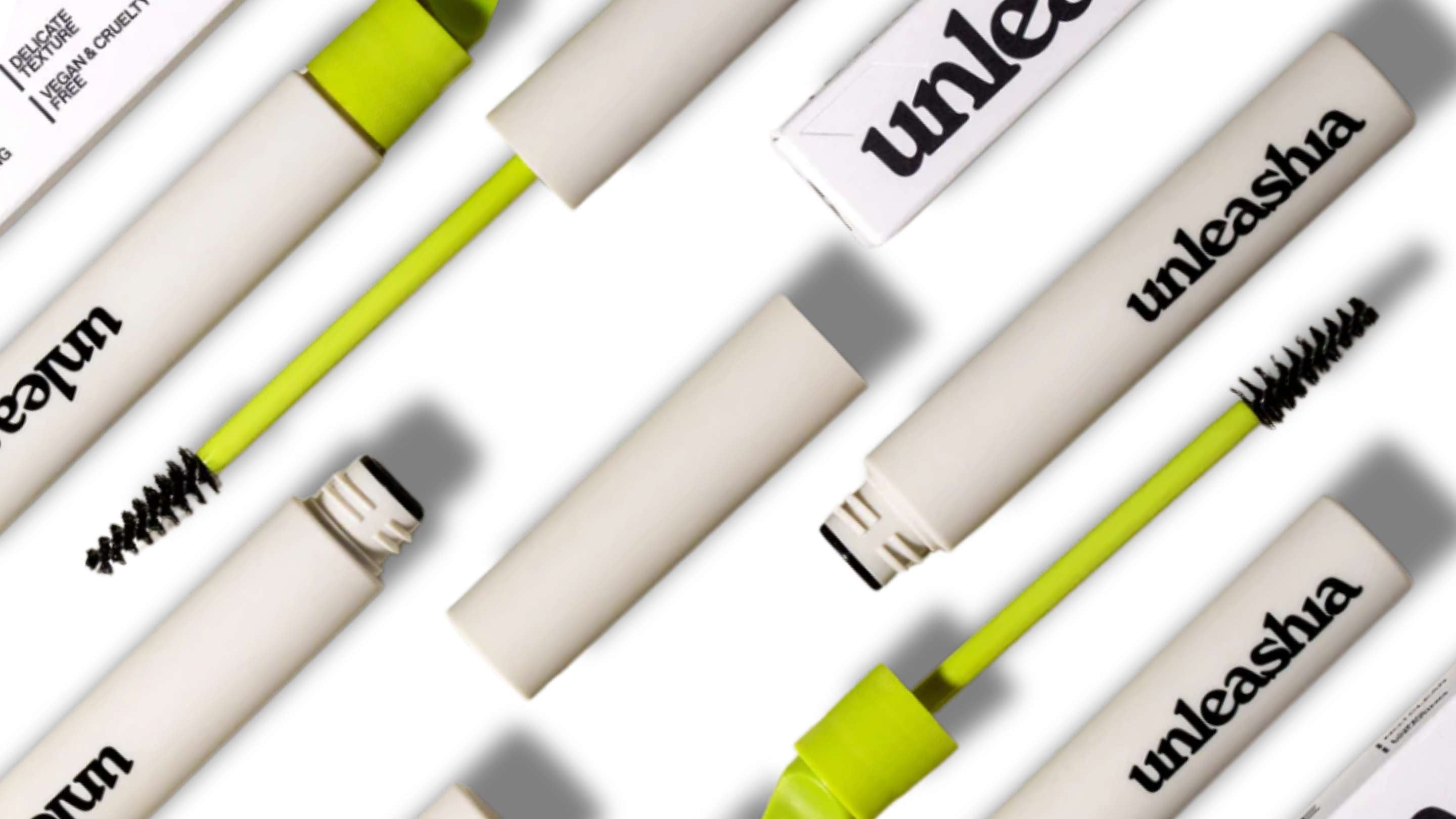 Bilden visar flera ögonbrynsverktyg från märket Unleasha, inklusive penslar och tuber för ögonbrynspomade. Produkterna är stilfullt presenterade mot en neutral bakgrund, vilket framhäver deras sofistikerade och moderna design.