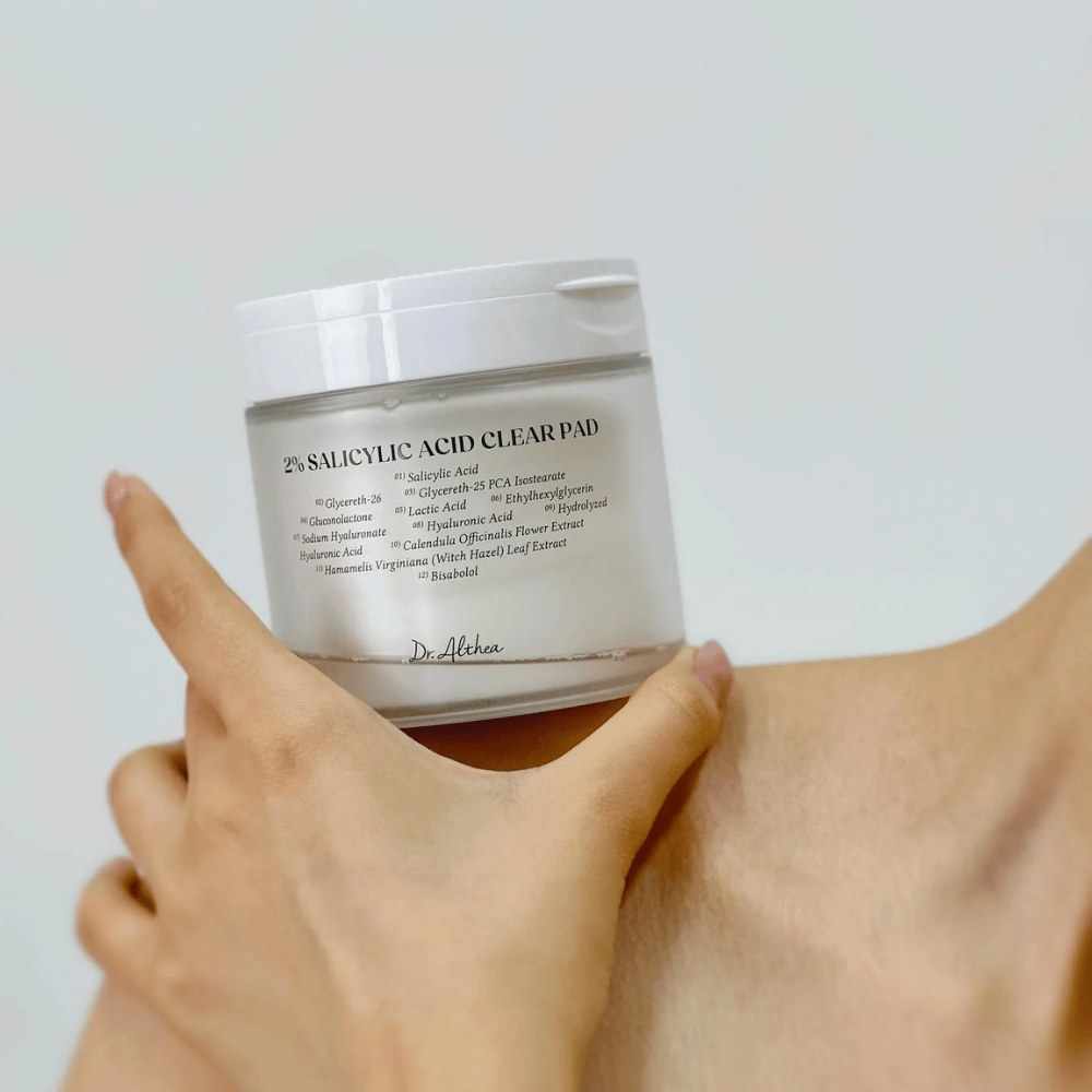 Dr. Althea 2% Salicylic Acid Clear Pad trzymane w ręku. Płatki tonizujące z 2% kwasem salicylowym, które delikatnie eksfoliują, łagodzą skórę i poprawiają jej strukturę.