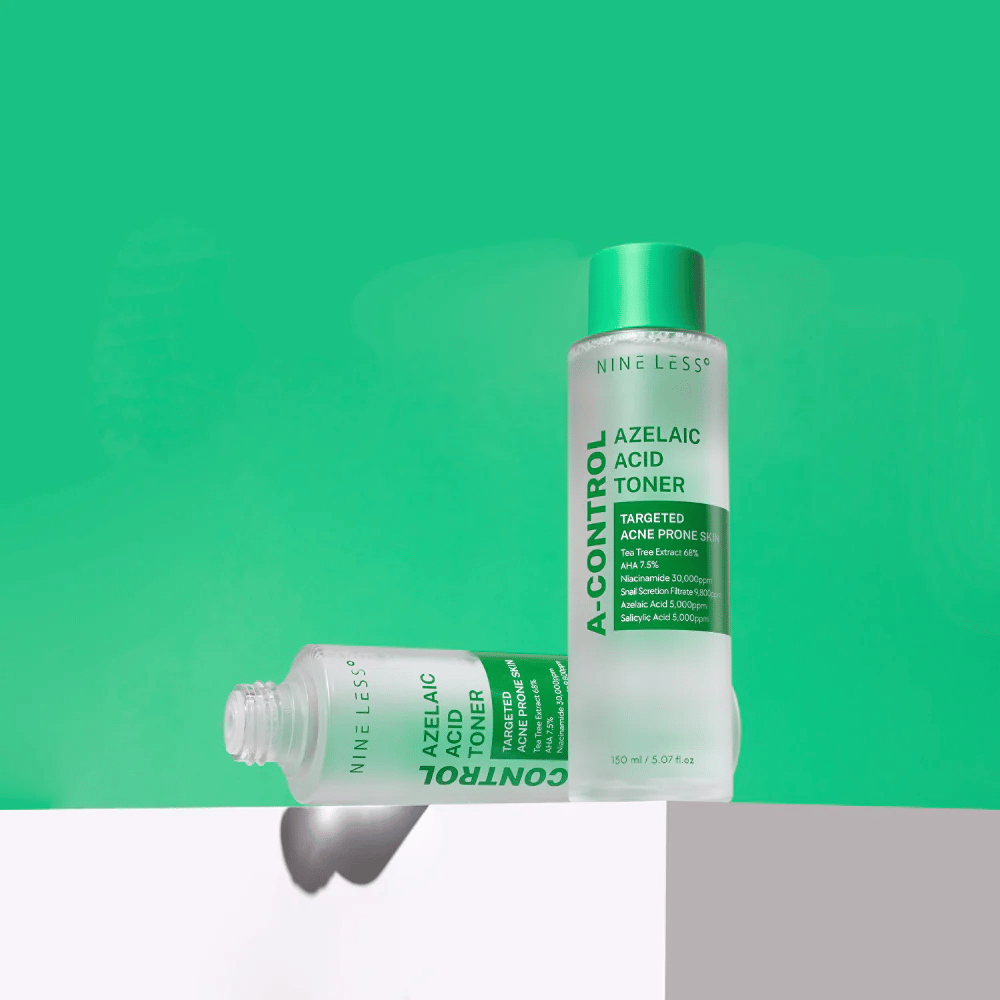 Dwie butelki Nine Less A-Control Azelaic Acid Toner ustawione na zielonym tle, jedna stojąca, druga leżąca.