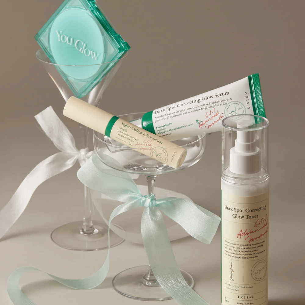 Obrazek Zestaw do pielęgnacji skóry od AXIS-Y z serum do oczu, serum i tonikiem – elegancko umieszczone w kieliszkach koktajlowych z jedwabnymi wstążkami, idealne na luksusową prezentację prezentową.