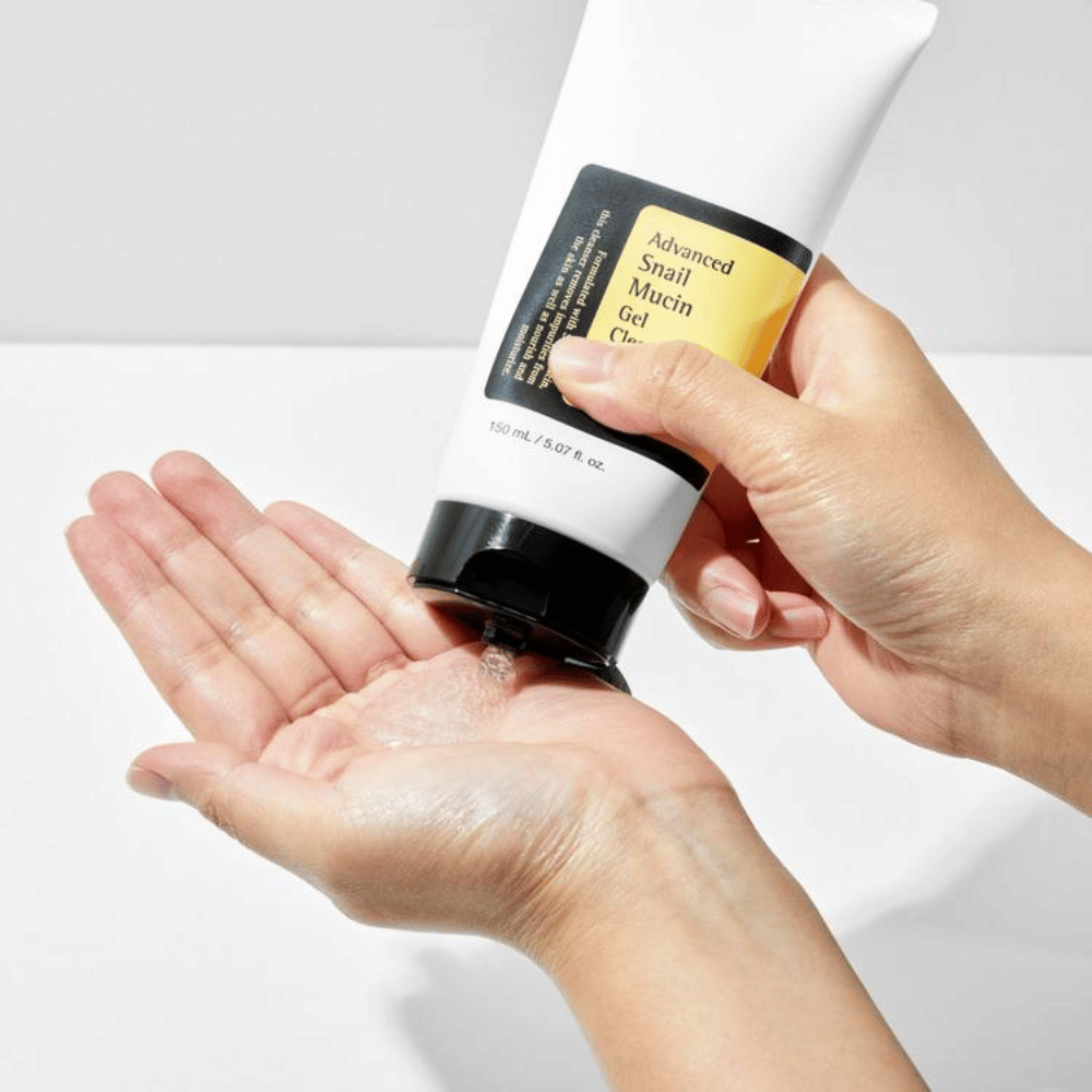 Ręka nakłada COSRX Advanced Snail Mucin Gel Cleanser – delikatne oczyszczanie żelowe z mucyną ślimaka, które głęboko oczyszcza i zachowuje równowagę wilgoci w skórze.