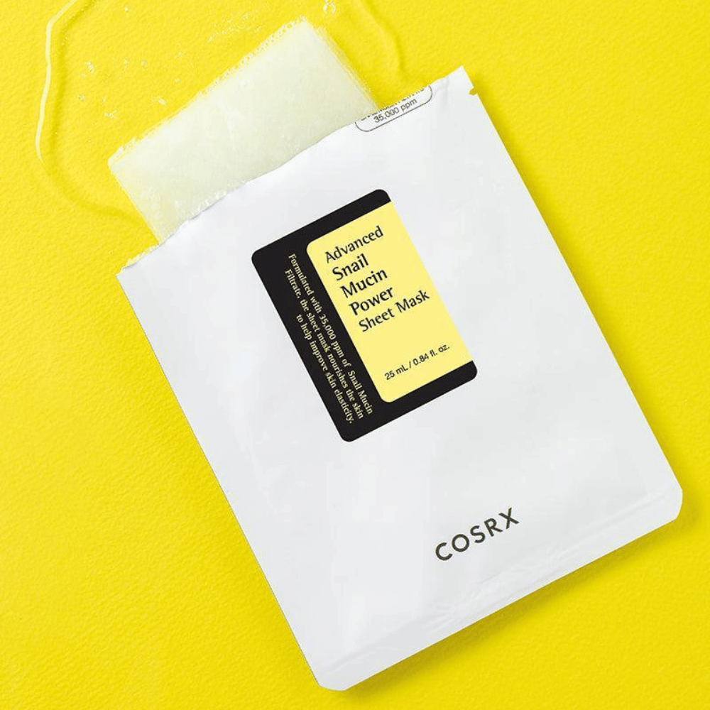 COSRX Advanced Snail Mucin Power Sheet Mask na żółtym tle, nawilżająca i regenerująca maseczka do twarzy z śluzem ślimaka dla zwiększenia elastyczności i blasku.