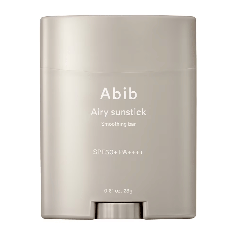 Obrazek przedstawia beżowy sztyft przeciwsłoneczny od Abib z napisem "Airy Sunstick Smoothing Bar" i filtrem SPF50+ PA++++, idealny do codziennej ochrony przed promieniami UV.