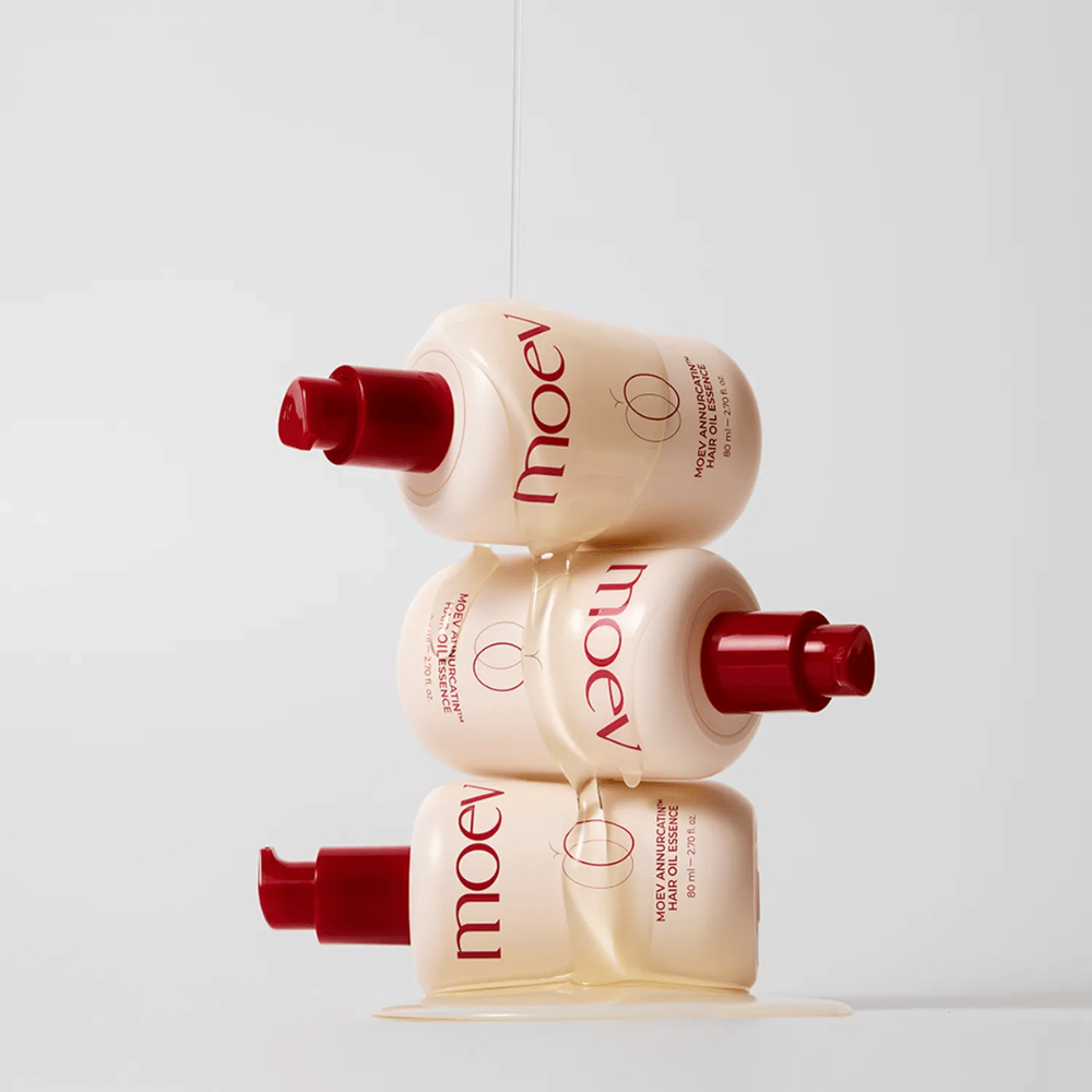 Trzy butelki MOEV Annurcatin Hair Oil Essence ustawione jedna na drugiej – odżywczy olejek do włosów z jabłkiem Annurca i biotyną, który wzmacnia, chroni i nadaje włosom blask oraz elastyczność.