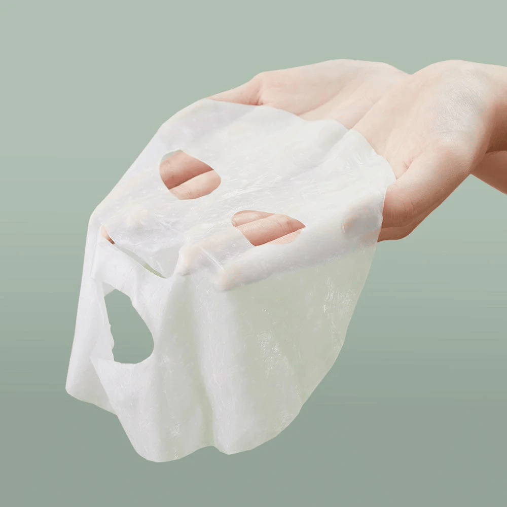 Ręka osoby trzymającej Anua Heartleaf 77% Soothing Sheet Mask.