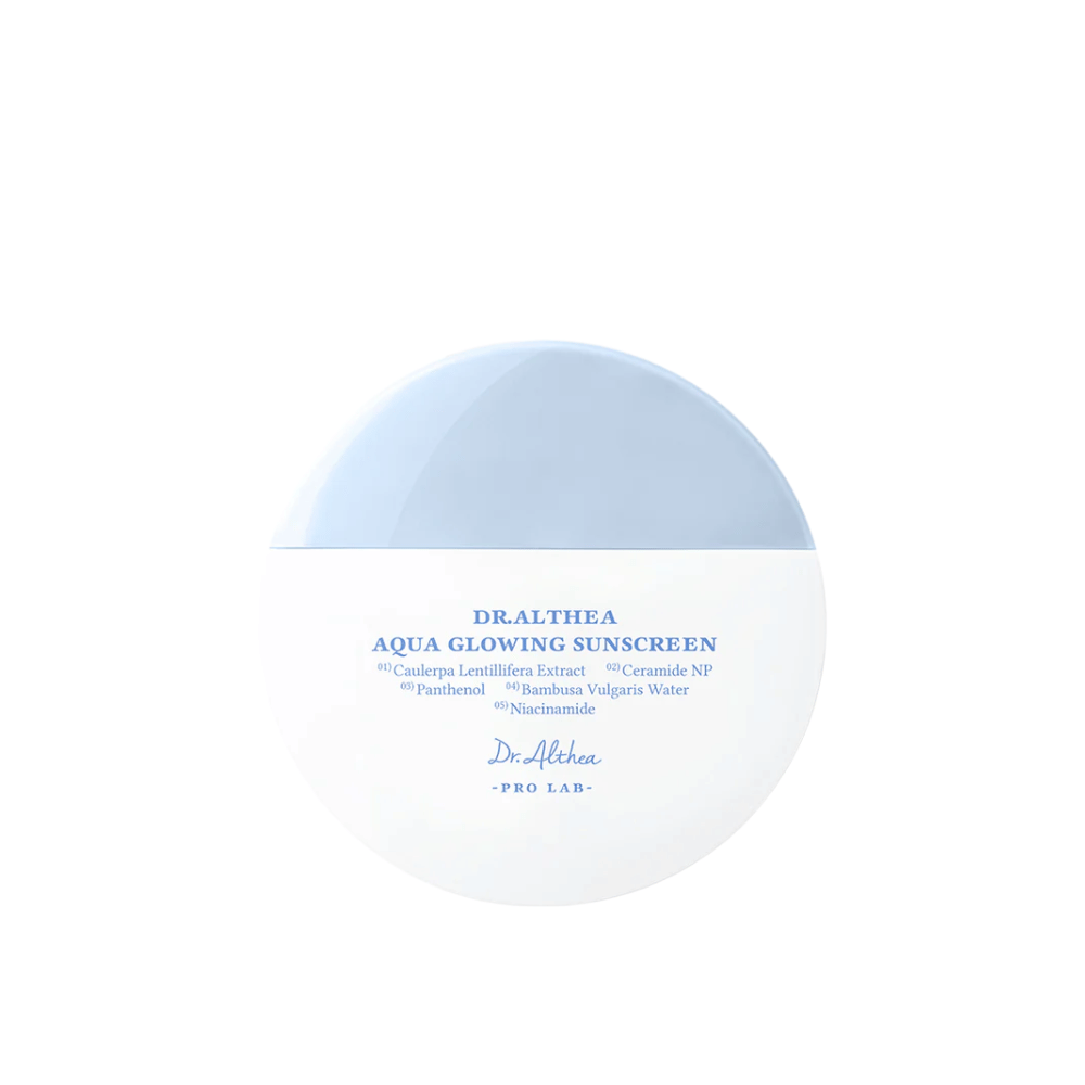 Zdjęcie produktu Dr. Althea Aqua Glowing Sunscreen – okrągły krem przeciwsłoneczny w białym i jasnoniebieskim opakowaniu z niebieskim tekstem podkreślającym nawilżające składniki, takie jak niacynamid i ceramidy.