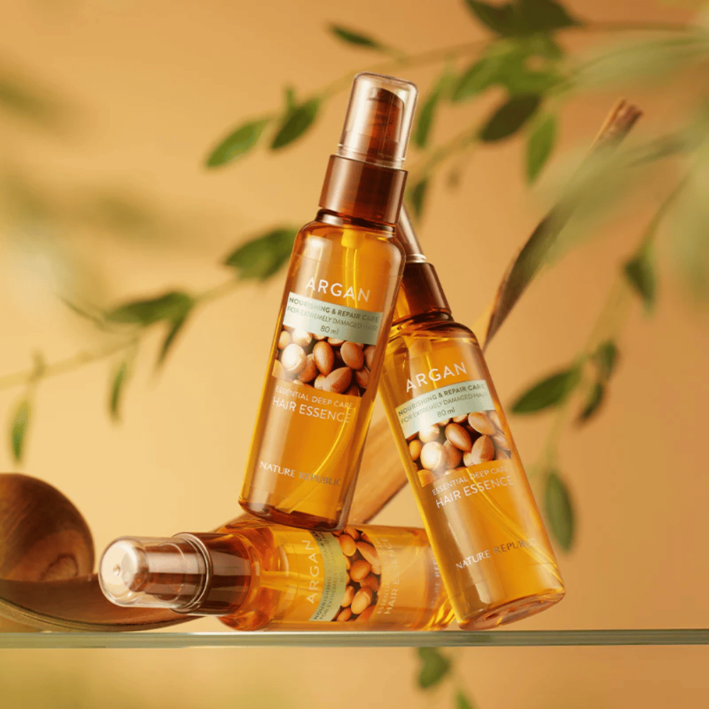 Trzy butelki Nature Republic Argan Essential Moisture Hair Oil z olejem arganowym – odżywia, nadaje blask i naprawia zniszczone włosy.