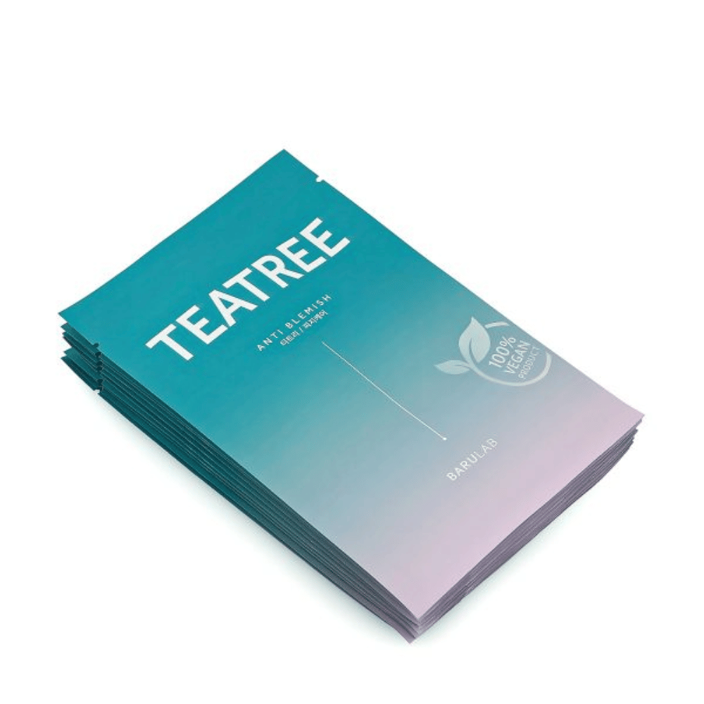 Stos opakowań masek BARULAB "TEATREE Anti Blemish", wszystkie oznaczone jako "100% Vegan Product". Opakowania mają jednolity turkusowy kolor.