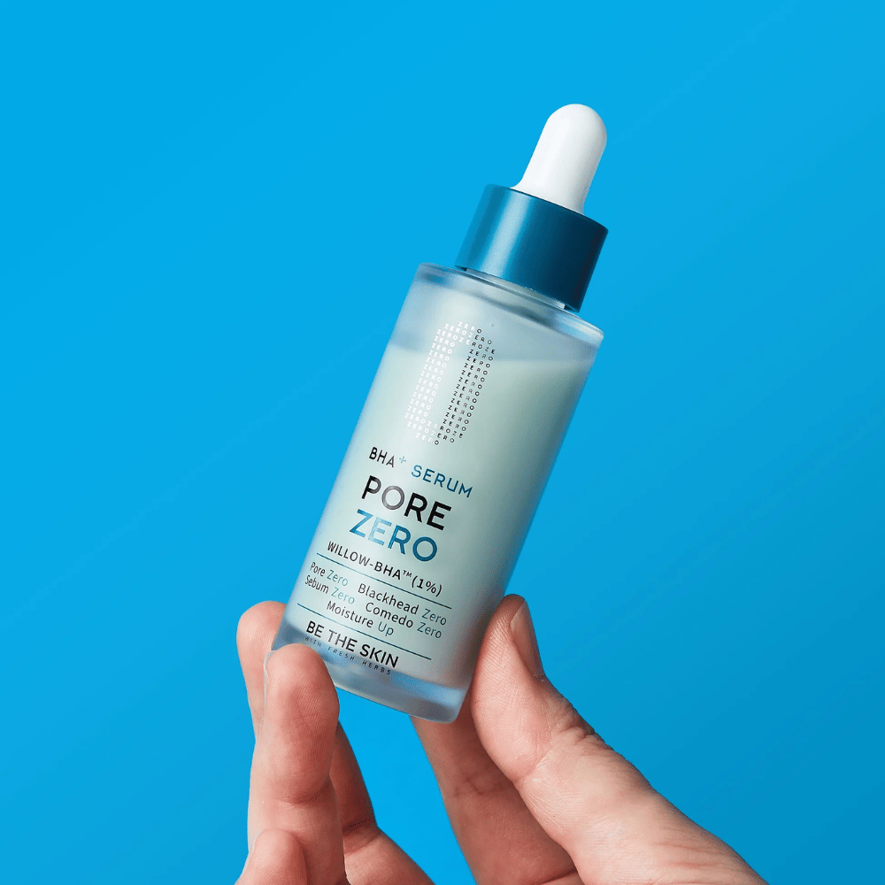 Be The Skin BHA+ Pore Zero Serum trzymany w dłoni na niebieskim tle