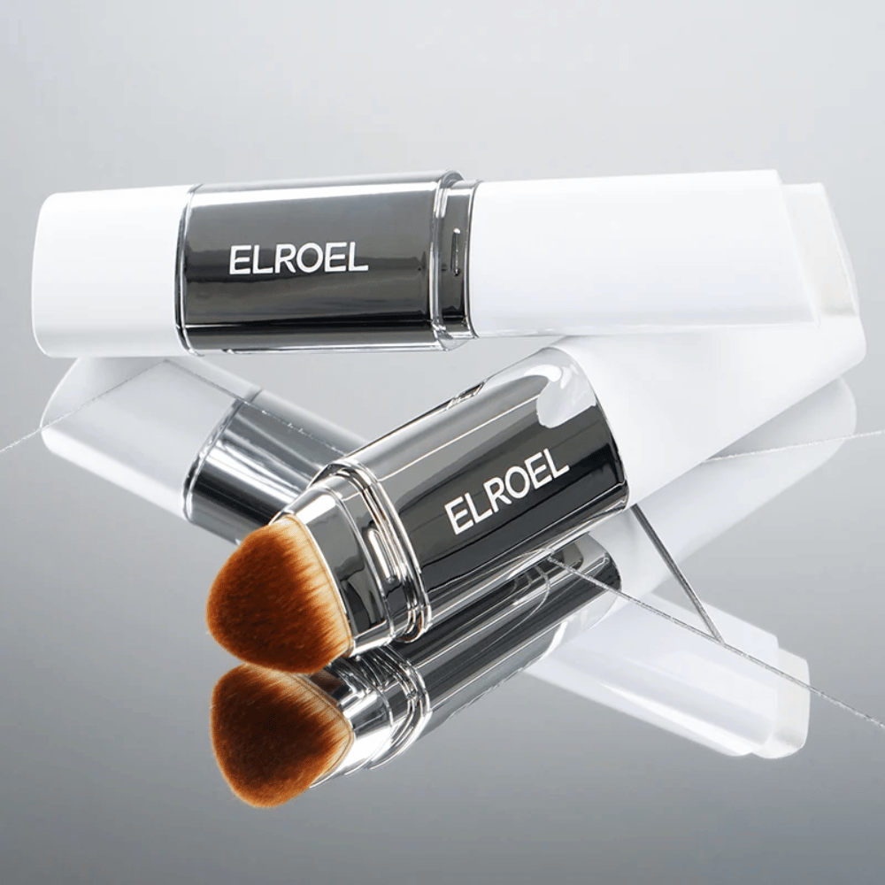 ELROEL Blanc Cover Cream Stick z wbudowanym pędzlem umieszczonym na lustrzanej powierzchni, aby pokazać miękkie włosie i równomierną aplikację.