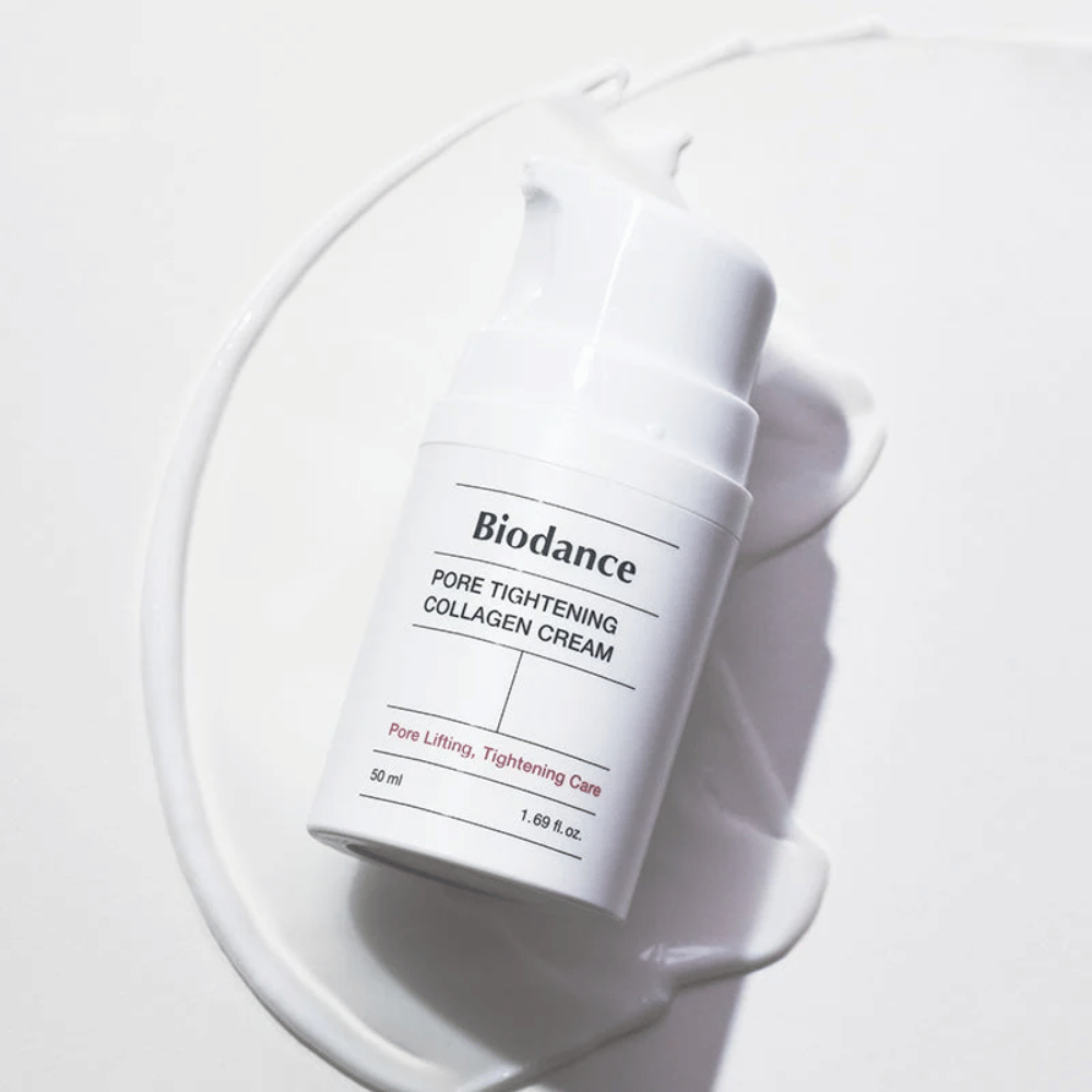 Biodance Pore Tightening Collagen Cream w białej butelce z pompką, leżące na wirze białego kremu.
