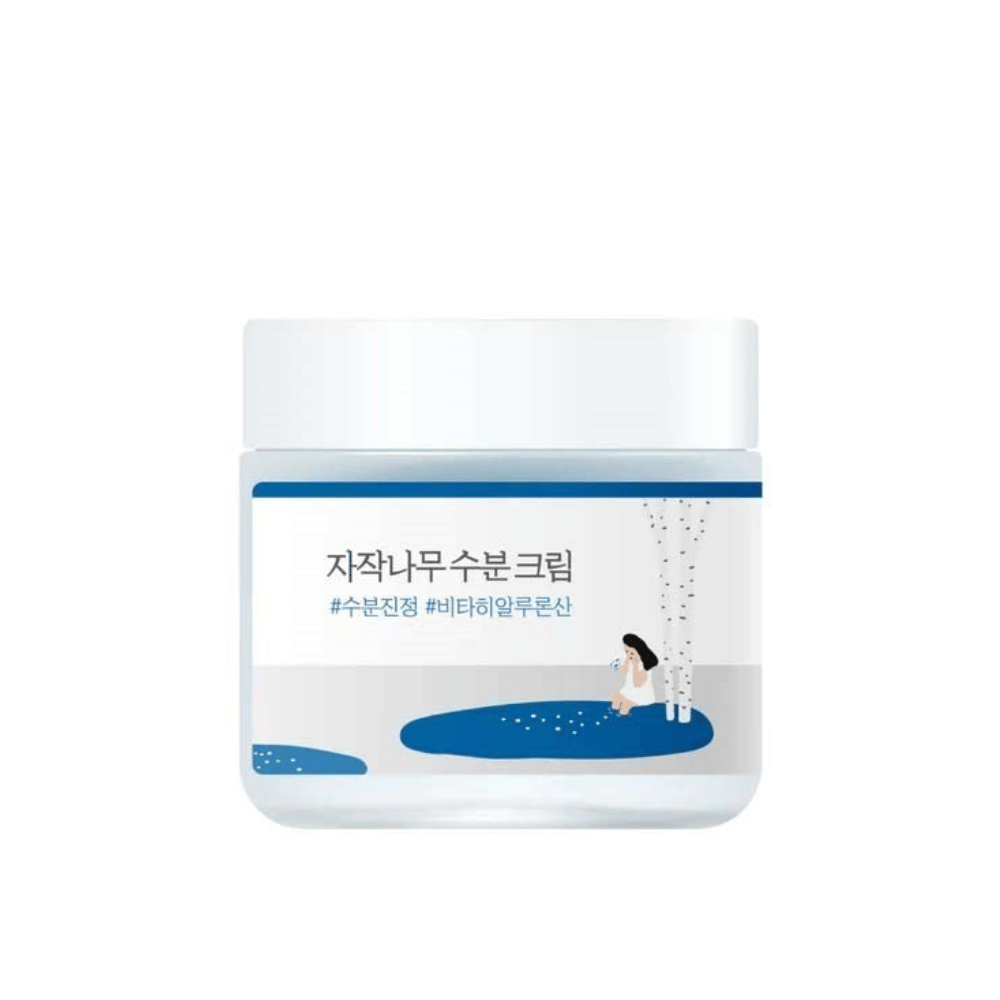 Round Lab Birch Juice Moisturizing Cream w przezroczystym słoiku z białą pokrywką i niebieską etykietą z ilustracją brzozy i dziewczyny, wycięty na białym tle.