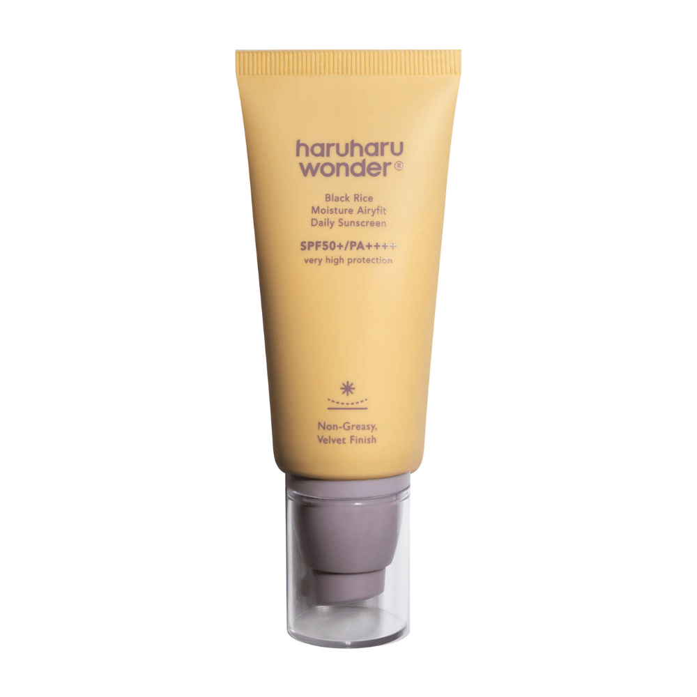 Żółta tubka z Haruharu Wonder Black Rice Moisture Airyfit Daily Sunscreen SPF 50+ PA++++. Tubka ma przezroczystą zakrętkę i tekst opisujący wysoki poziom ochrony kremu przeciwsłonecznego oraz jego nietłustą, aksamitną konsystencję.