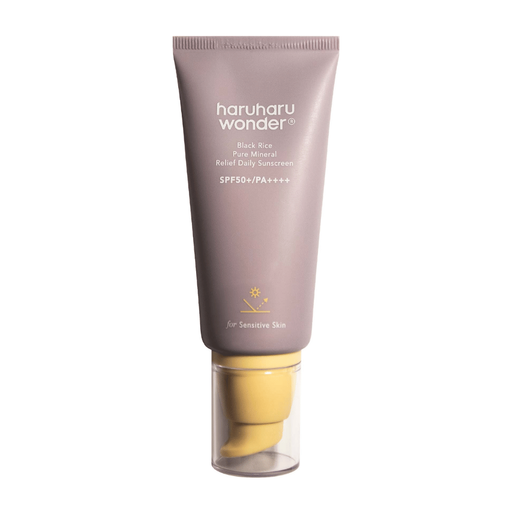 Fioletowa tubka z Haruharu Wonder Black Rice Pure Mineral Relief Daily Sunscreen SPF 50+ PA++++. Tubka ma przezroczystą nakrętkę i tekst opisujący wysoki poziom ochrony kremu przeciwsłonecznego, specjalnie dostosowany do wrażliwej skóry.