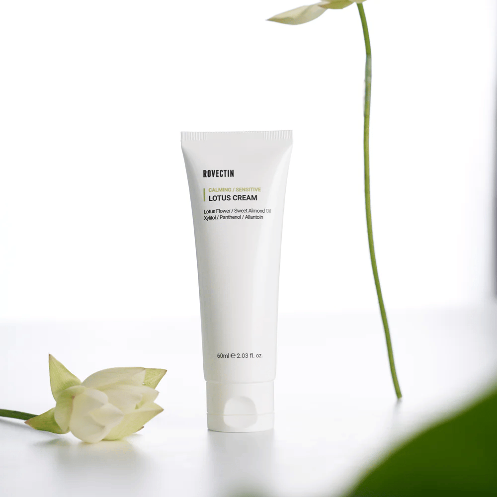 Tuba z Rovectin Lotus Cream do łagodzenia i pielęgnacji wrażliwej skóry, zaprezentowana z kwiatem lotosu.