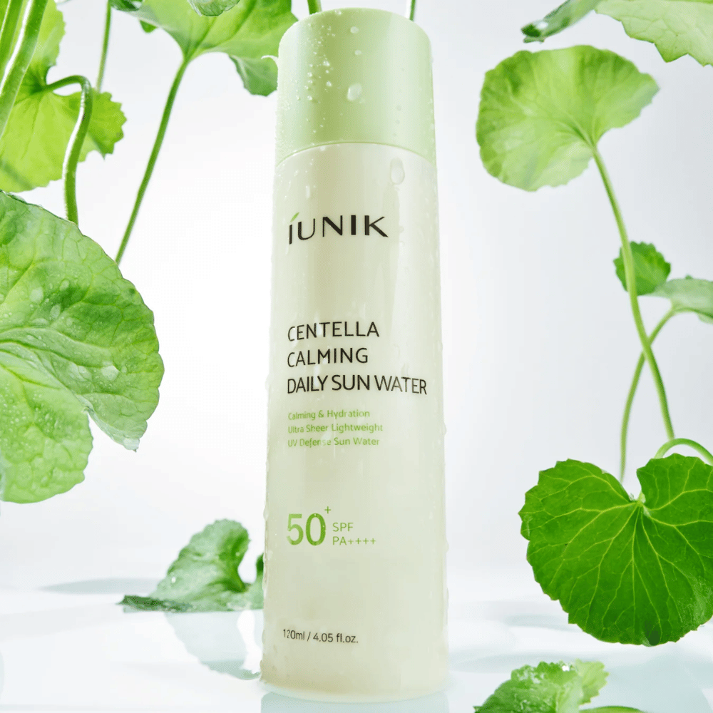 2. iUNIK Centella Calming Daily Sun Water SPF50+ PA++++ – nawilżający krem przeciwsłoneczny z centella asiatica otoczony zielonymi liśćmi i kroplami wody