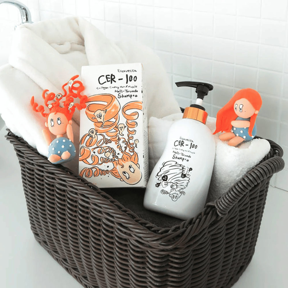 Zdjęcie prezentacyjne z Elizavecca CER-100 Shampoo i opakowaniem produktu umieszczonymi w koszu razem z ręcznikami. Zabawne postacie z projektu opakowania podkreślają unikalny i kreatywny styl marki.