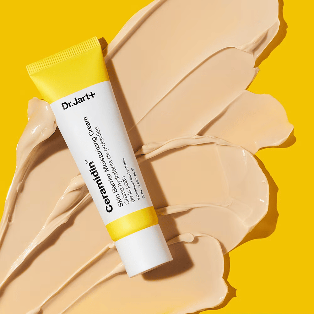 Tuba z Dr. Jart+ Ceramidin Skin Barrier Moisturizing Cream na żółtym tle z rozsmarowanym kremem.