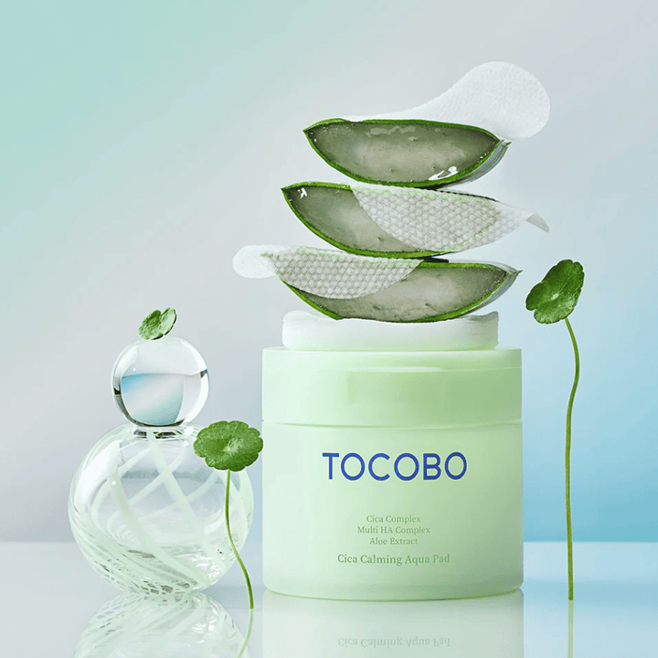 TOCOBO Cica Calming Aqua Pad pokazany wraz z toner pads, aloesem i wąkrotą azjatycką. Obraz podkreśla nawilżające i łagodzące składniki produktu.
