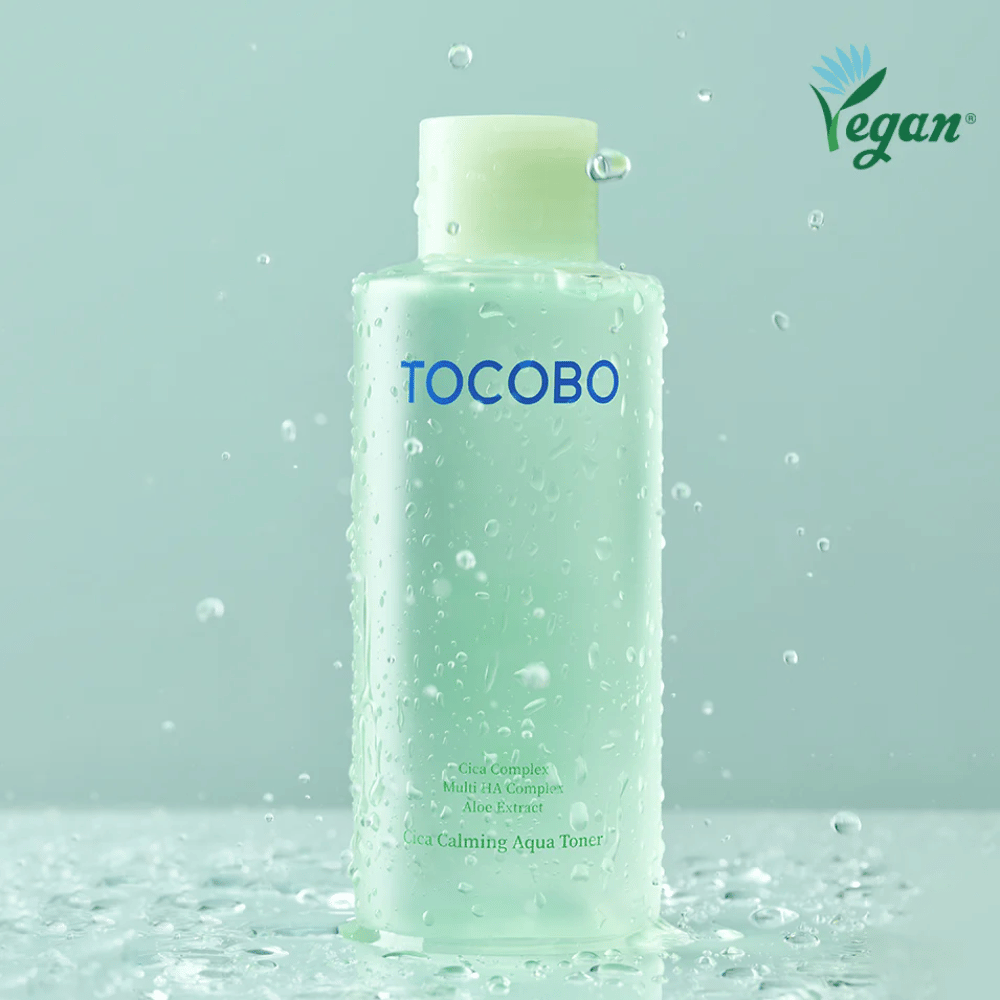 Zdjęcie produktu TOCOBO Cica Calming Aqua Toner otoczonego kroplami wody, które podkreślają nawilżające i kojące właściwości toniku dla skóry wrażliwej.
