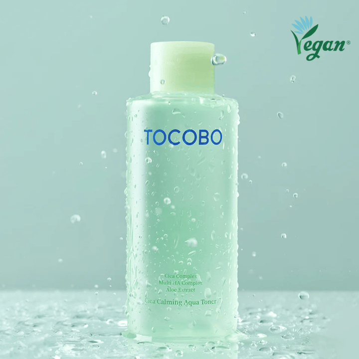 Zdjęcie produktu TOCOBO Cica Calming Aqua Toner otoczonego kroplami wody, które podkreślają nawilżające i kojące właściwości toniku dla skóry wrażliwej.