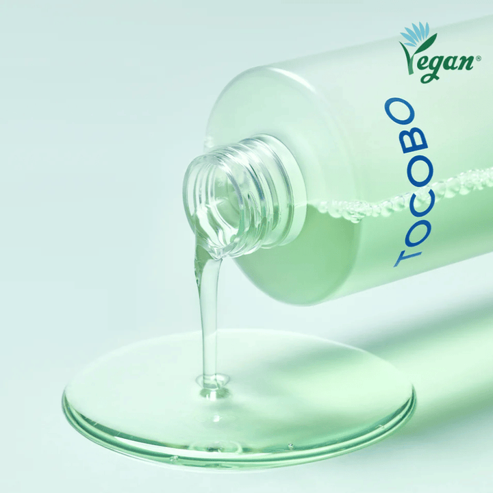 Zbliżenie TOCOBO Cica Calming Aqua Toner, który jest wylewany, aby podkreślić przejrzystą, lekką i chłodzącą konsystencję produktu.