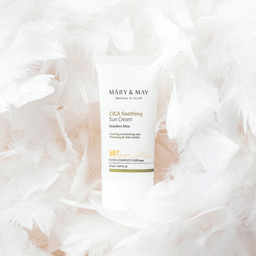 Mary&May CICA Soothing Sun Cream otoczony miękkimi białymi piórami. Obraz przekazuje poczucie delikatności, komfortu i lekkiej formuły dostosowanej do skóry wrażliwej.