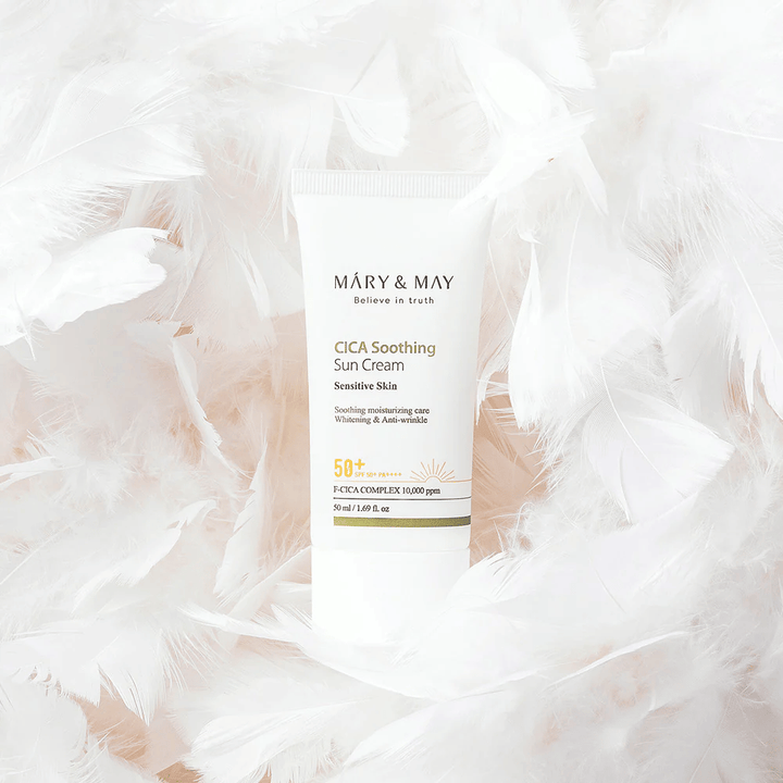 Mary&May CICA Soothing Sun Cream otoczony miękkimi białymi piórami. Obraz przekazuje poczucie delikatności, komfortu i lekkiej formuły dostosowanej do skóry wrażliwej.