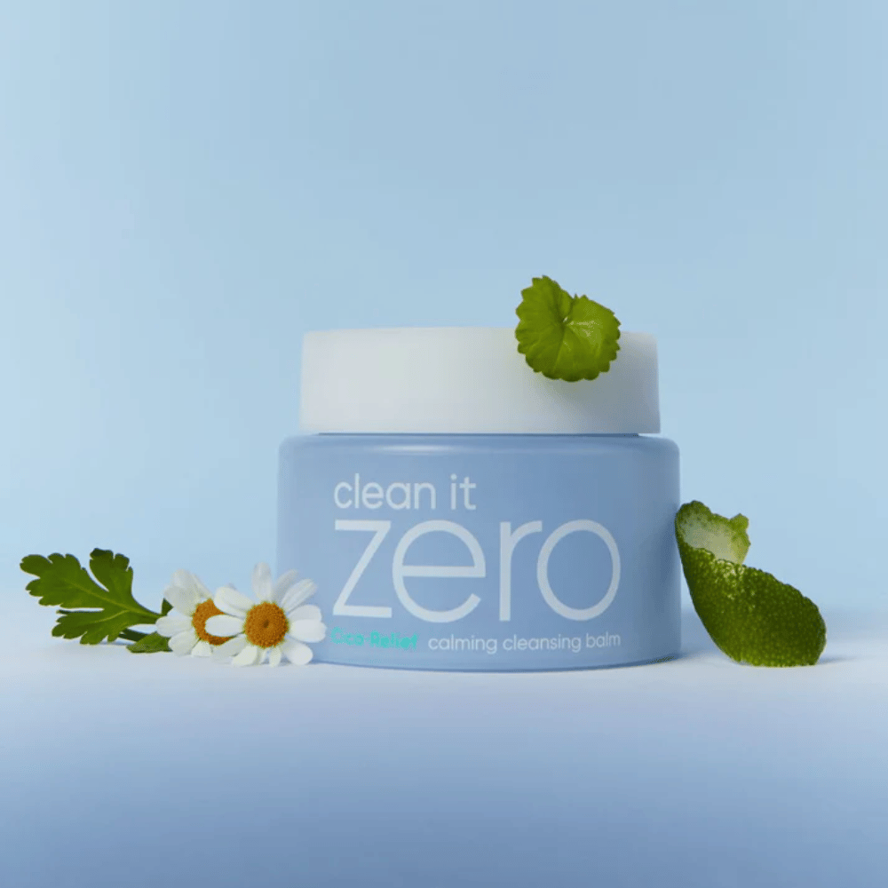 Clean It Zero Cica-Relief Calming Cleansing Balm umieszczony z roślinami i kwiatami, ilustruje łagodne oczyszczanie z kojącym CICA dla skóry wrażliwej i podrażnionej.