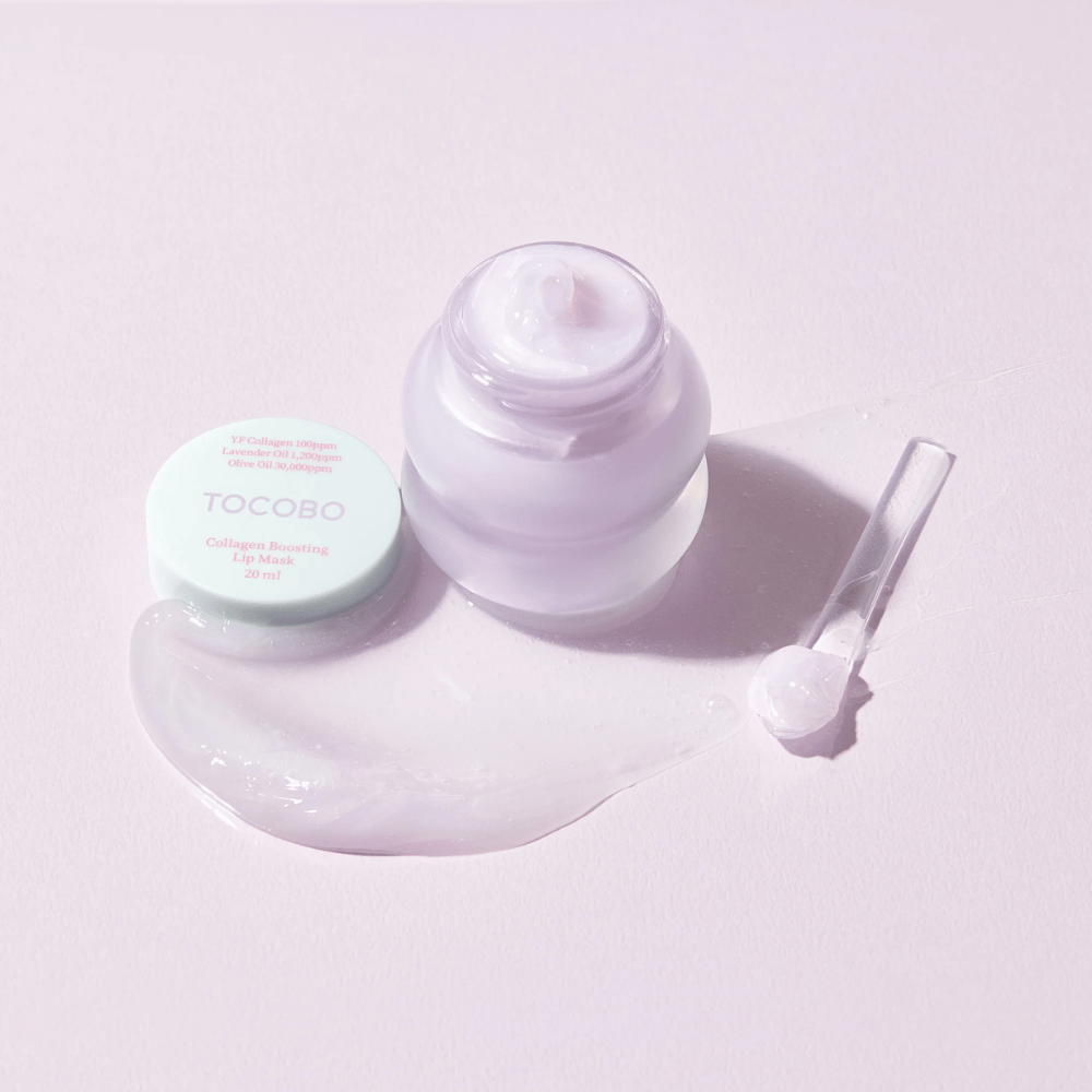 Otwarty słoik TOCOBO Collagen Boosting Lip Mask z szpatułką i rozproszonym fioletowym kremem na jasnofioletowym tle.