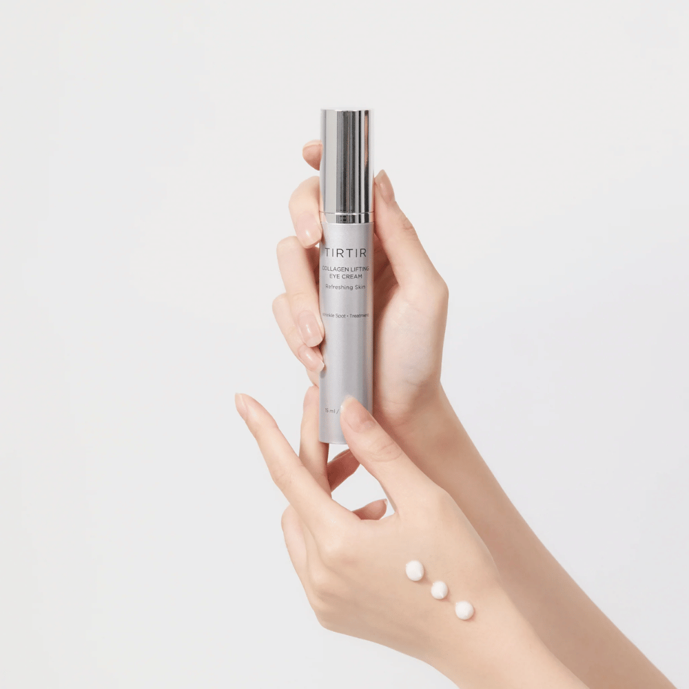 Ręce trzymające tubę z TIRTIR Collagen Lifting Eye Cream, z produktem wyciśniętym na grzbiet dłoni.