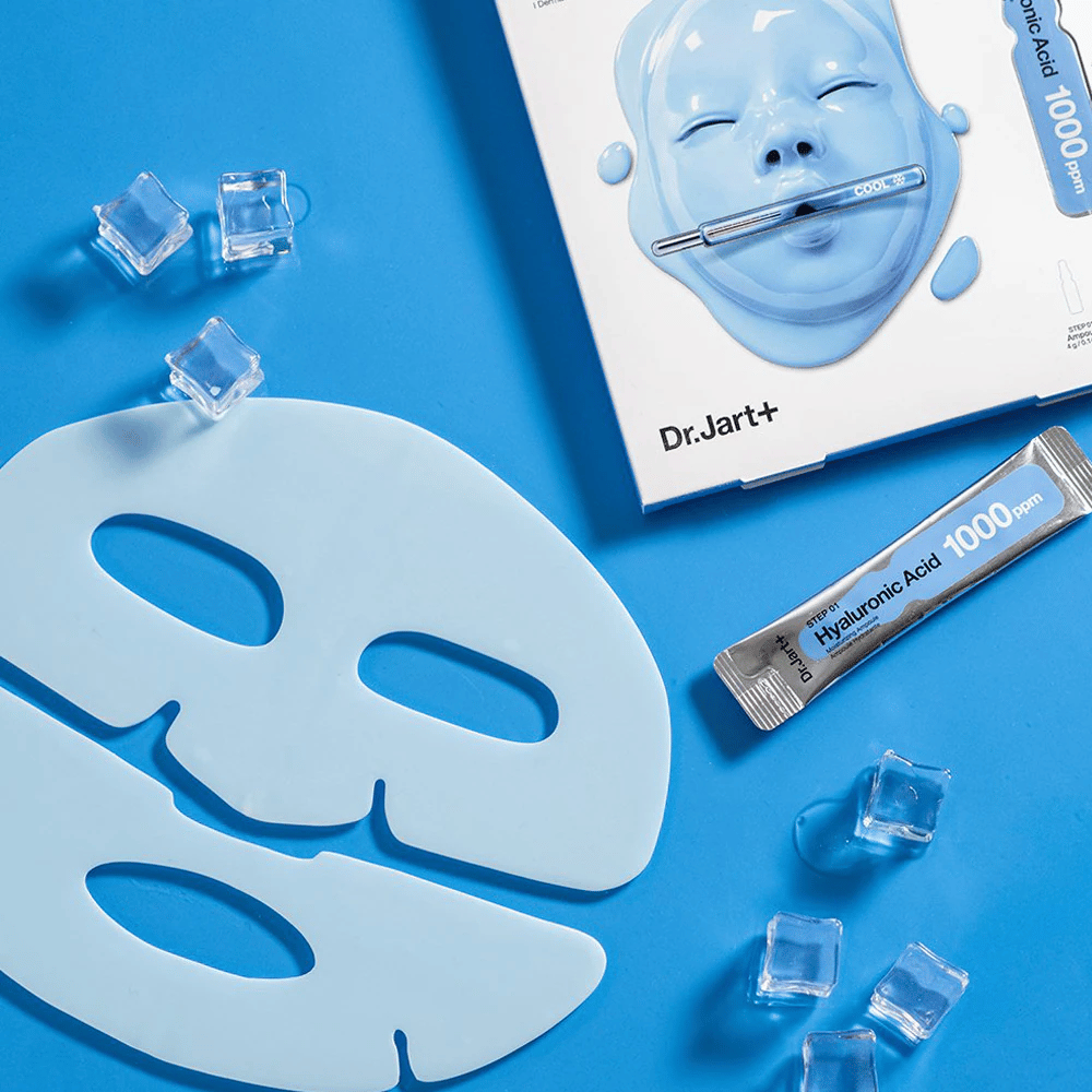 Dr.Jart+ Cryo Rubber Moisturizing Mask z dwuczęściową niebieską gumową maską, kostkami lodu, ampułką z kwasem hialuronowym i opakowaniem na niebieskim tle.