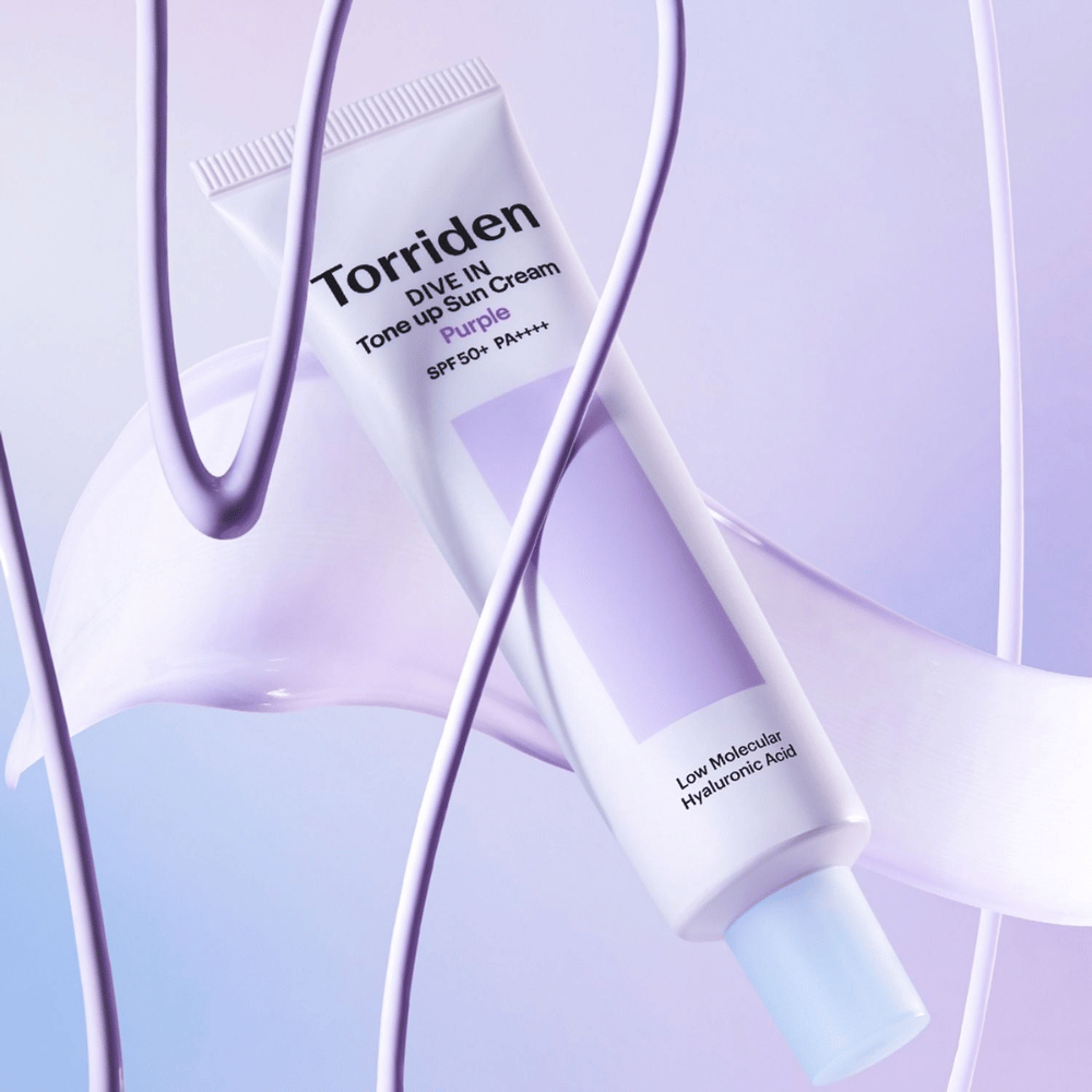 Torriden DIVE IN Tone Up Sun Cream Purple SPF50+ PA++++ przedstawiony w kreatywnym otoczeniu produktowym z fioletowymi detalami, które podkreślają nawilżającą formułę.