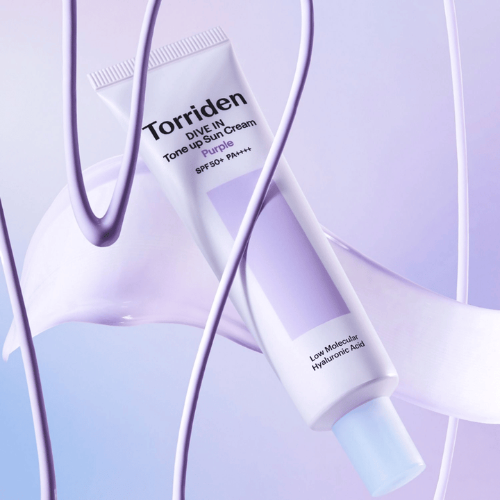 Torriden DIVE IN Tone Up Sun Cream Purple SPF50+ PA++++ przedstawiony w kreatywnym otoczeniu produktowym z fioletowymi detalami, które podkreślają nawilżającą formułę.