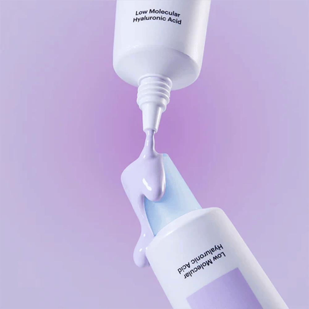 Zbliżenie na Torriden DIVE IN Tone Up Sun Cream Purple, gdzie fioletowy krem jest aplikowany z tubki, aby zilustrować konsystencję produktu.
