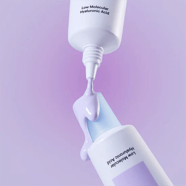 Zbliżenie na Torriden DIVE IN Tone Up Sun Cream Purple, gdzie fioletowy krem jest aplikowany z tubki, aby zilustrować konsystencję produktu.