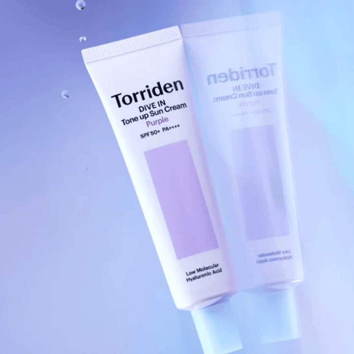 Torriden DIVE IN Tone Up Sun Cream Purple SPF50+ PA++++ sfotografowany na miękkim fioletowym tle, które podkreśla odbijający światło design produktu.