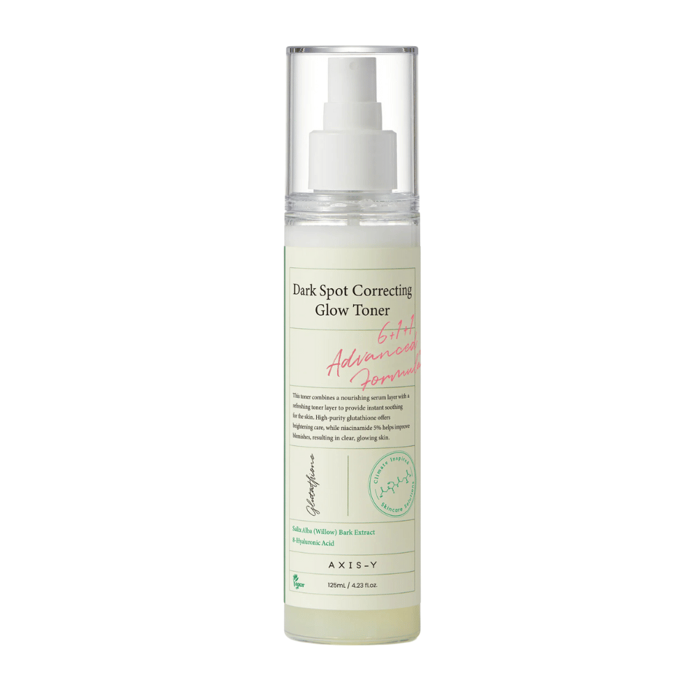 Zdjęcie butelki produktu "AXIS-Y Dark Spot Correcting Glow Toner". Butelka jest przezroczysta z białą etykietą i tekstem w kolorze czarnym i zielonym. Produkt to toner w sprayu, a butelka zawiera 125 ml (4,23 fl. oz). Etykieta wymienia kluczowe składniki, takie jak ekstrakt z kory wierzby i kwas hialuronowy.