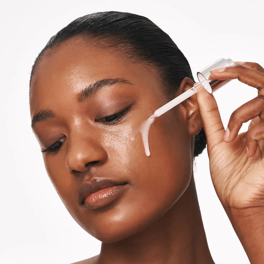 Osoba nakłada Deep Collagen Power Boosting Cream in Serum na policzek za pomocą pipety. Serum zapewnia jędrniejszą, nawilżoną skórę z blaskiem.