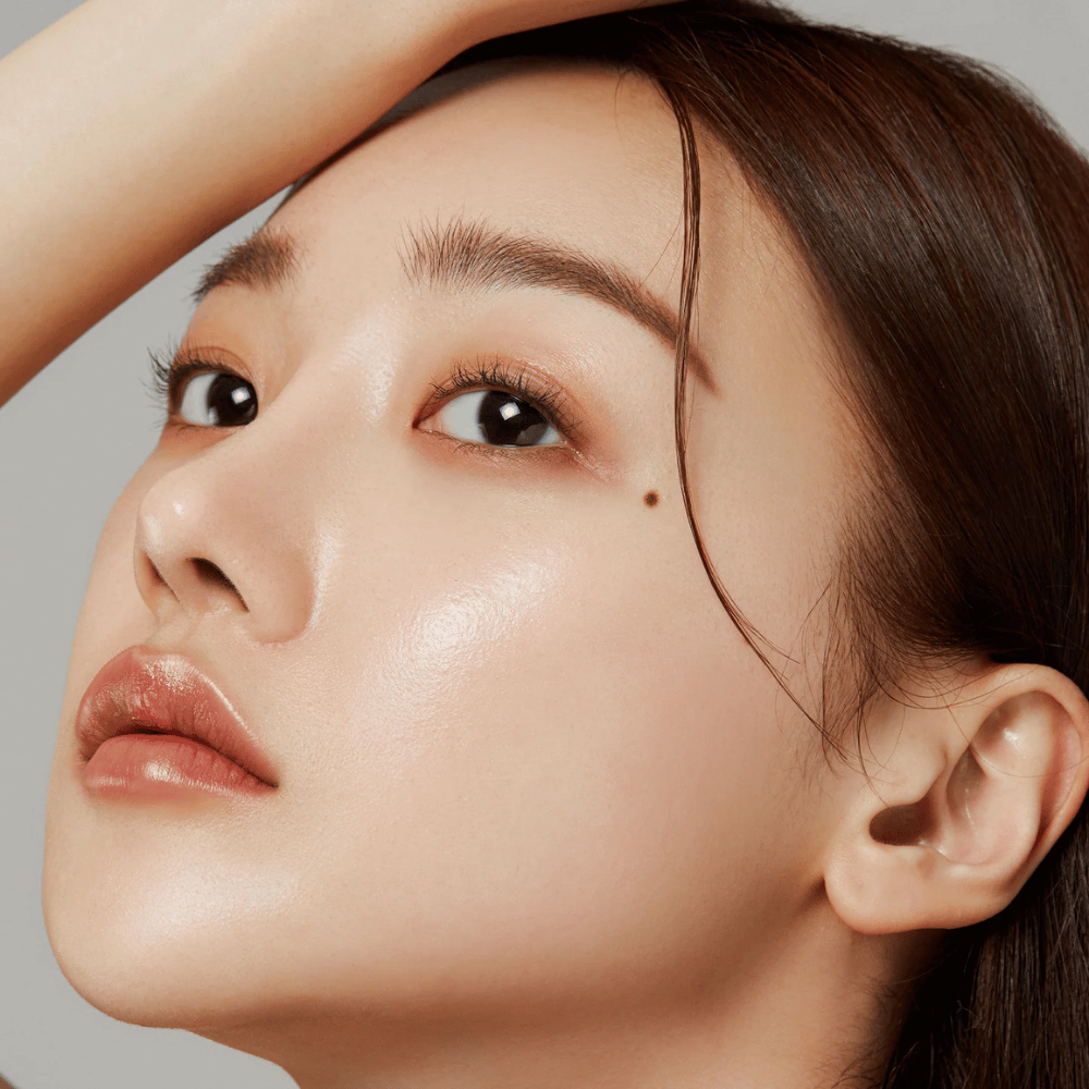 Zbliżenie na skórę z blaskiem – wynik działania Medicube Deep Lifting Peptide Eye Cream, który wzmacnia elastyczność skóry i nawilża.
