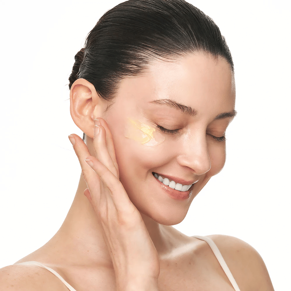 Osoba wciera Sungboon Editor Deep Collagen Retinol Capsule Cream w policzek. Produkt zapewnia blask, jędrność i długotrwałe nawilżenie.