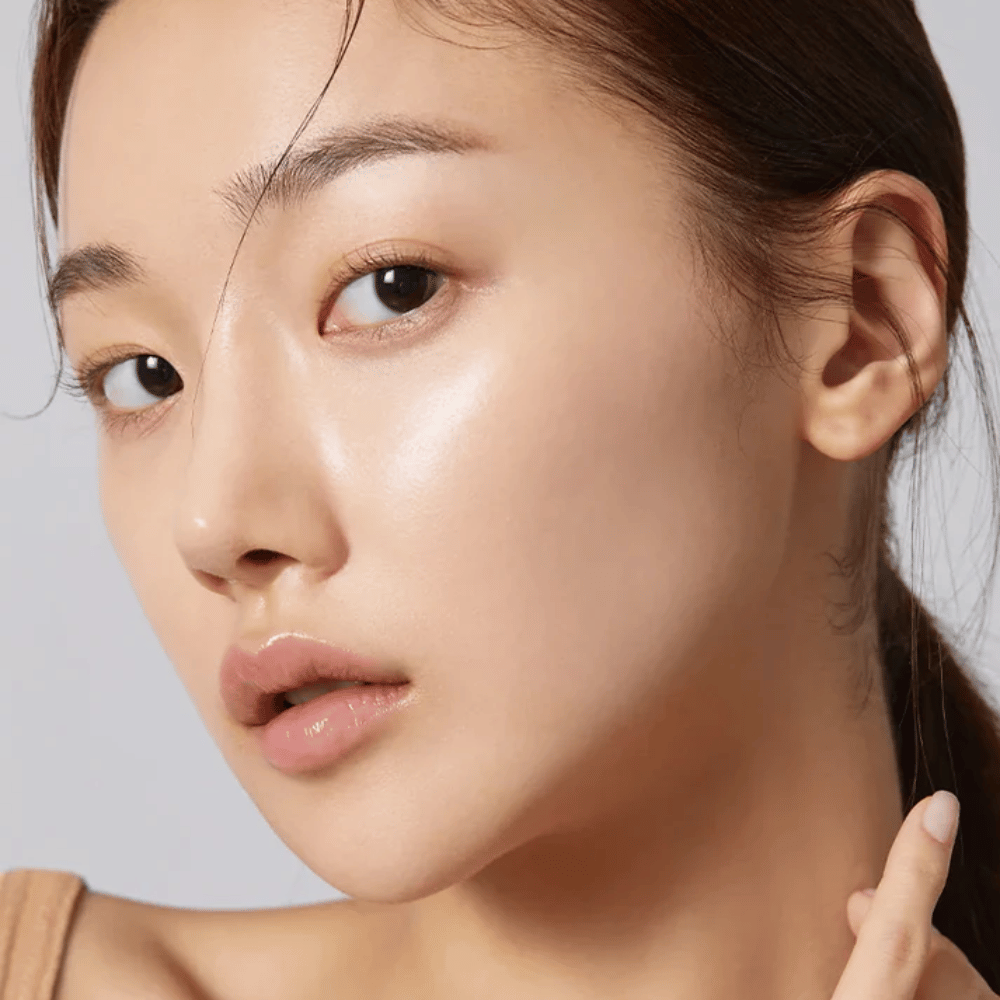 Zbliżenie na modelkę z czystą, nawilżoną skórą i naturalnym blaskiem po użyciu koreańskiej Maseczka w płachcie.