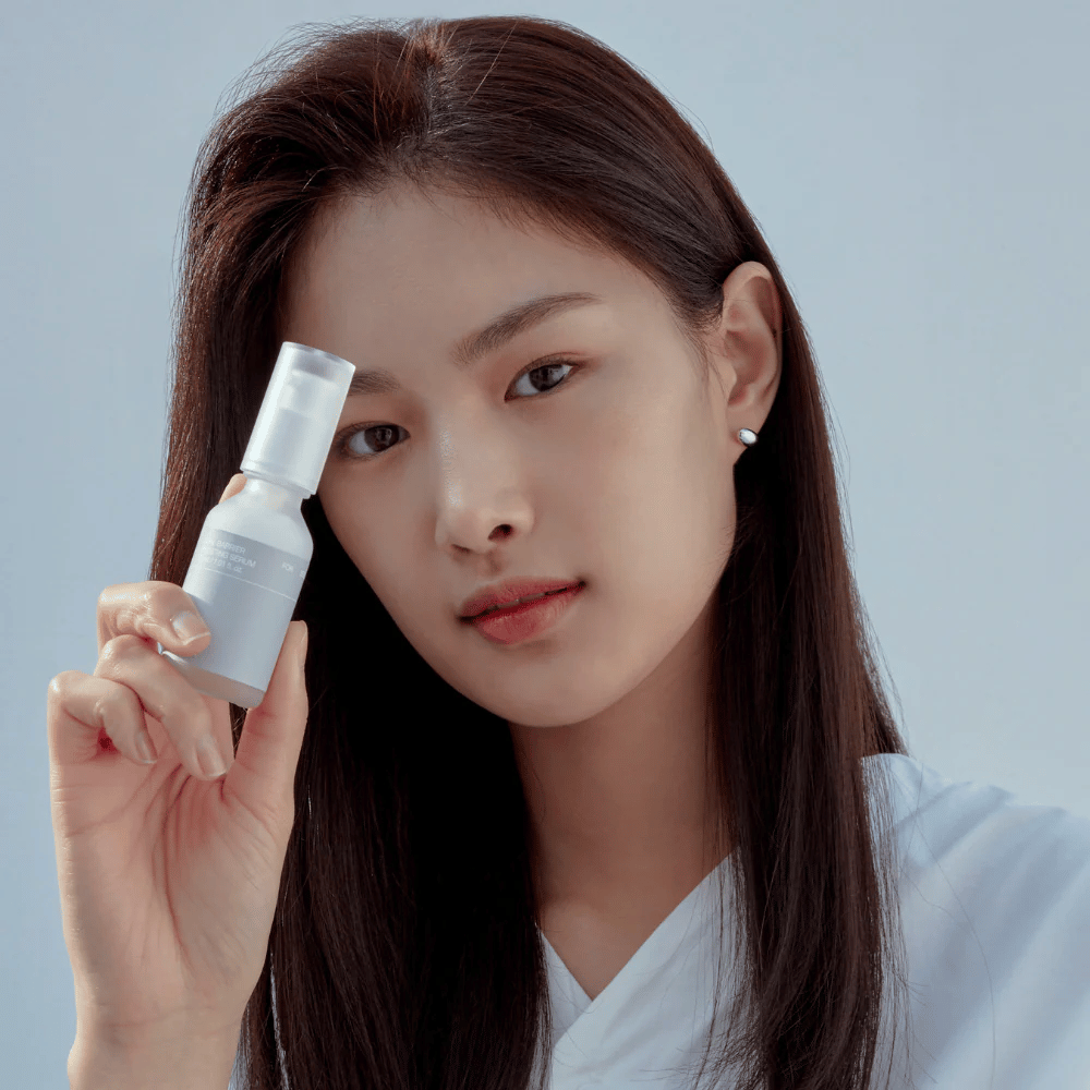 Model trzyma Celimax Dual Barrier Boosting Serum, koreańska pielęgnacja skóry wzmacniająca barierę skórną i łagodząca wrażliwą skórę.