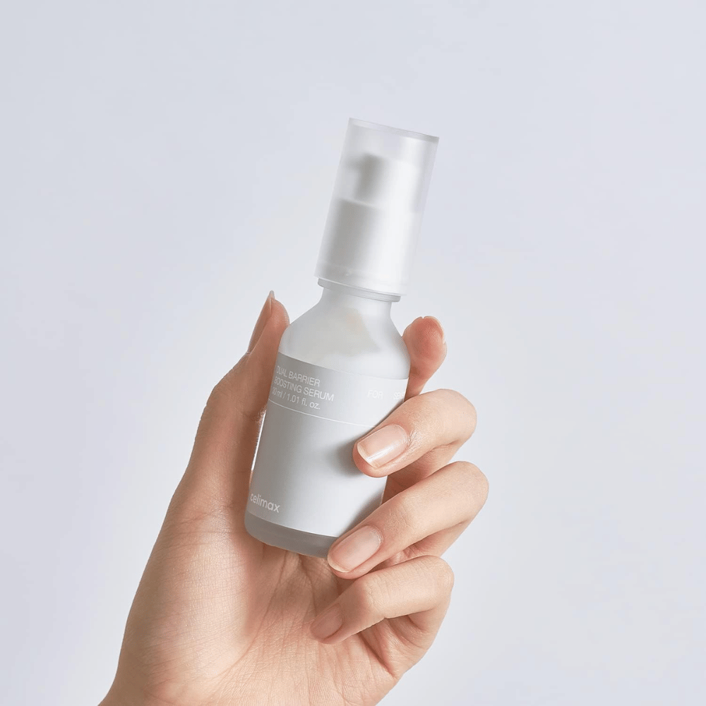 Celimax Dual Barrier Boosting Serum w ręce, minimalistyczne opakowanie pokazujące koreańskie serum wzmacniające barierę dla skóry wrażliwej.