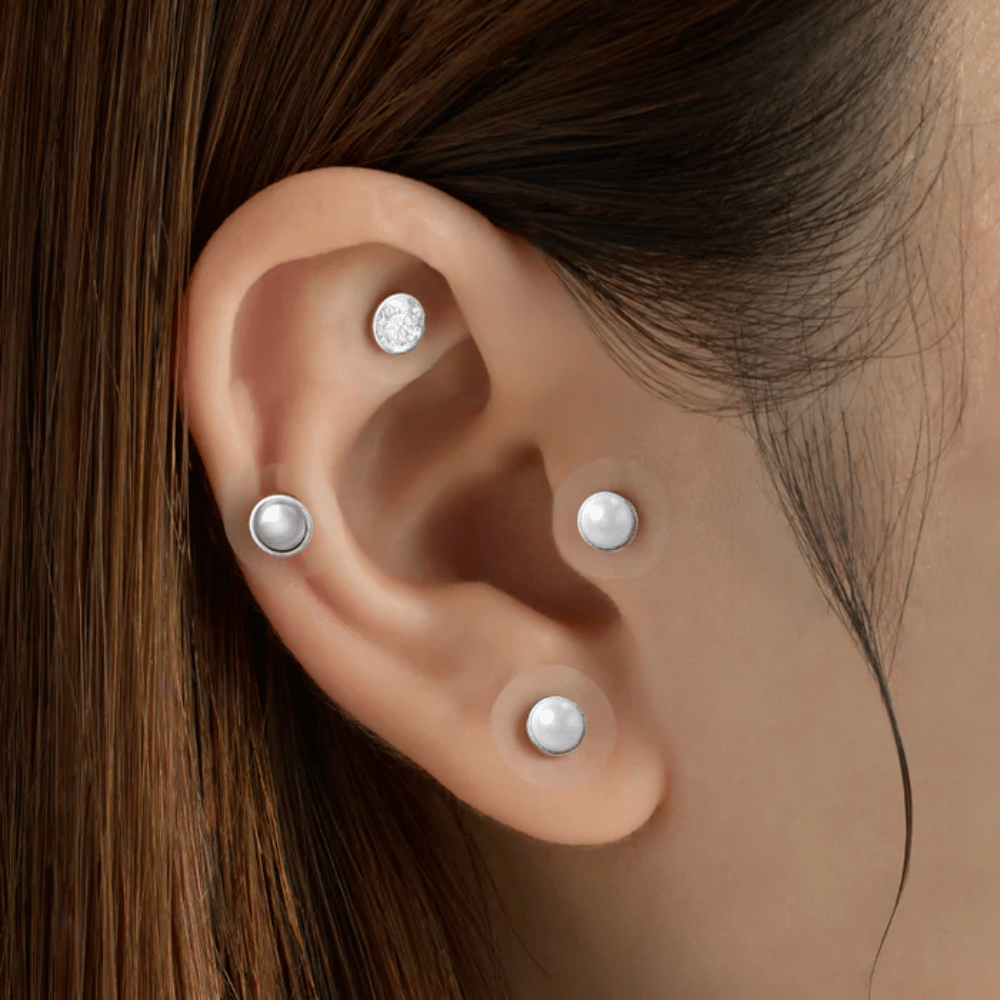 Zbliżenie ucha z kilkoma RETURNITY Ear Therapy Acupressure Patch nałożonymi na różne obszary ucha do akupresury i dla stylowego wyglądu.