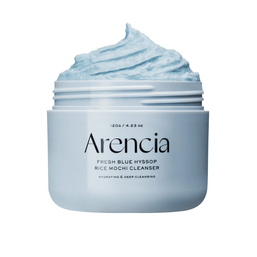 Zbliżenie na otwarty słoik Arencia Fresh Blue Hyssop Rice Mochi Cleanser. Niebieski krem czyszczący ma lekką, ubijaną teksturę i wypełnia górną część słoika.