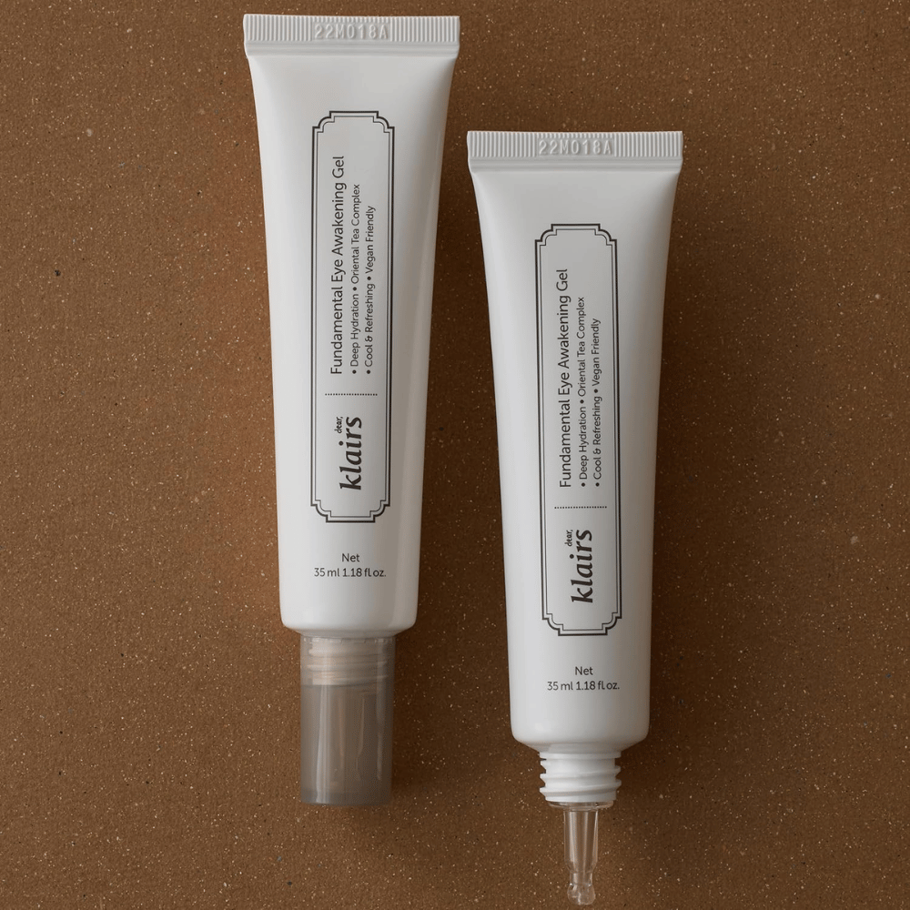 Zdjęcie produktowe przedstawiające Klairs Fundamental Eye Awakening Gel w dwóch wersjach – zamkniętą tubkę oraz otwartą tubkę podkreślającą wąską końcówkę aplikatora. Opakowanie ma minimalistyczny biały design i eksponuje nacisk produktu na nawilżenie, chłodzące uczucie oraz odświeżającą pielęgnację okolic oczu.