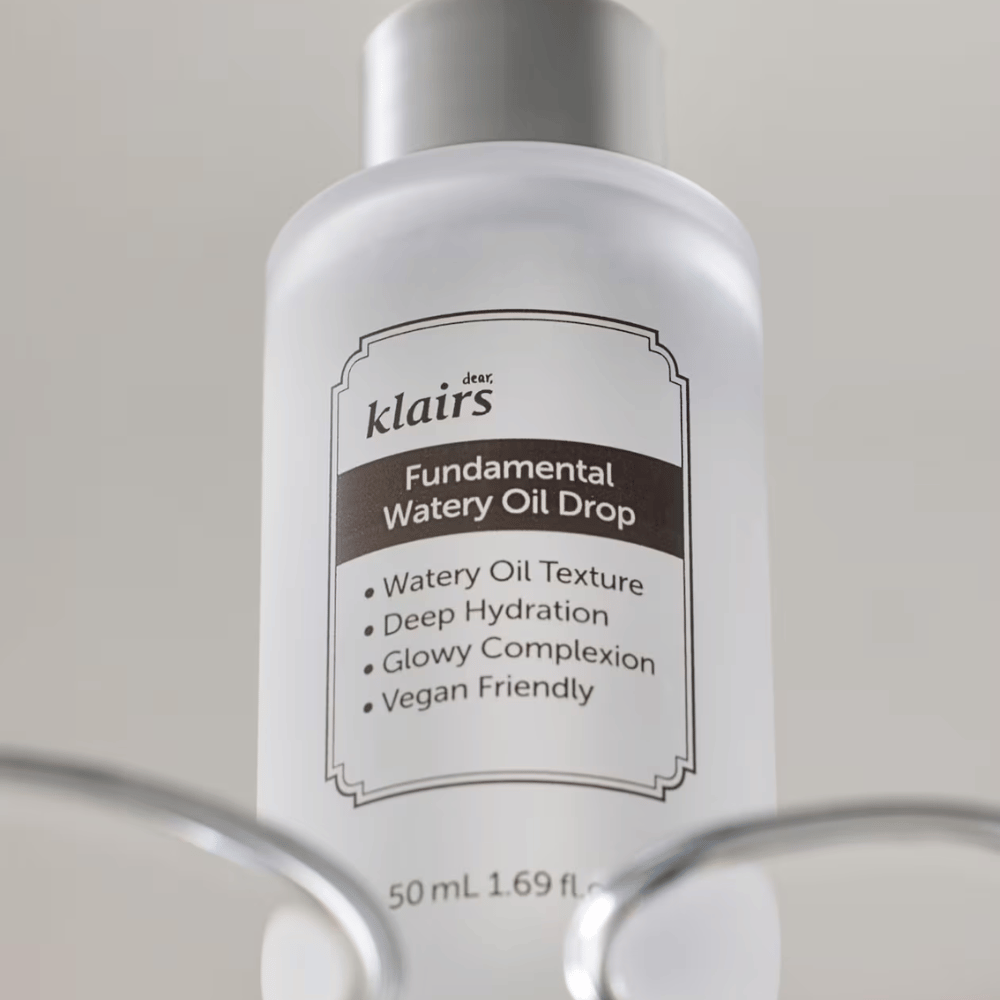 Butelka z Klairs Fundamental Watery Oil Drop, 50 ml, umieszczona w przezroczystym uchwycie, z wyraźną etykietą, która podkreśla nawilżające i wegańskie właściwości produktu.